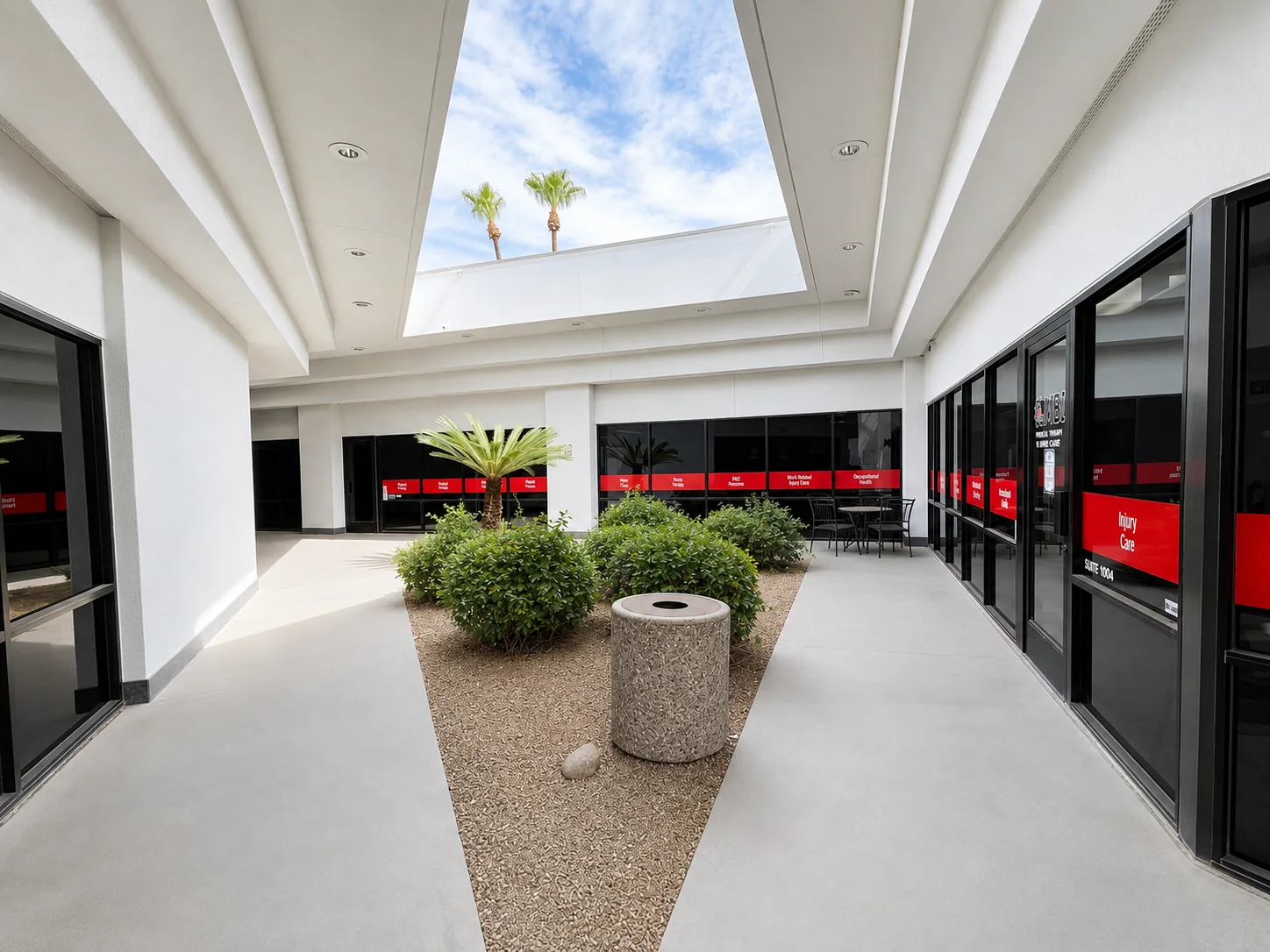 Skylit interior courtyard with sago palm, seating and suite entrances