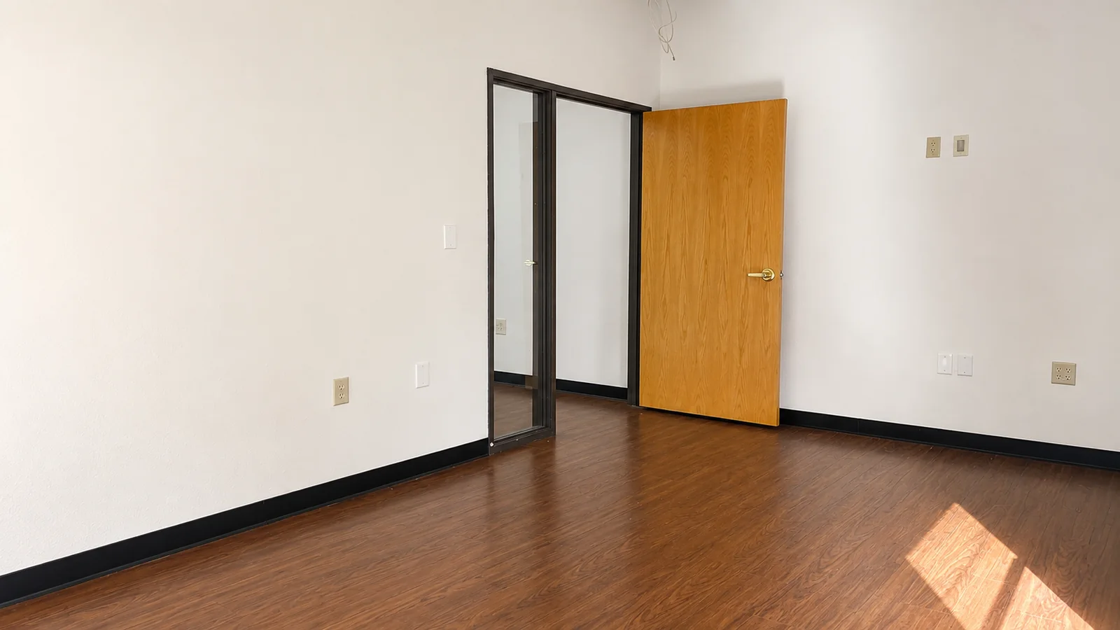 Private office inside Suite 100B with a glass sidelight and a wood door