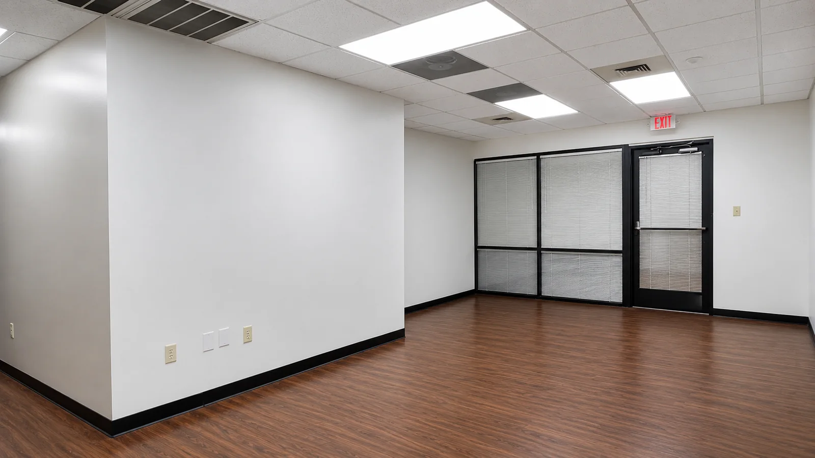 Front room of Suite 103B with glass-front offices and dark wood flooring