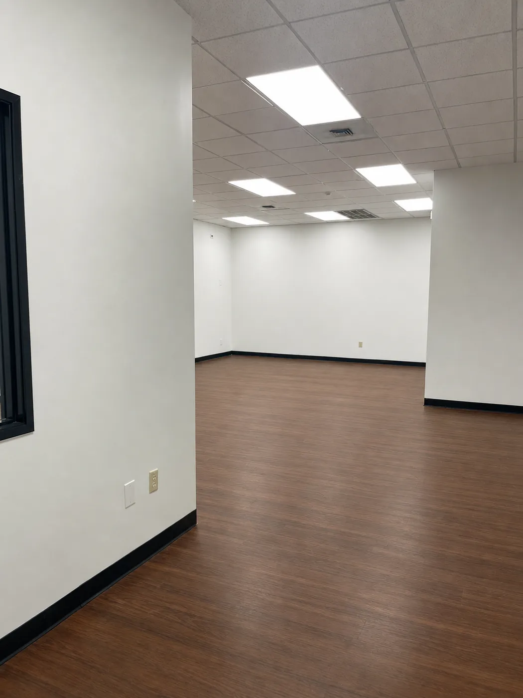 Open work area inside Suite 101B with new flooring and bright ceiling lighting